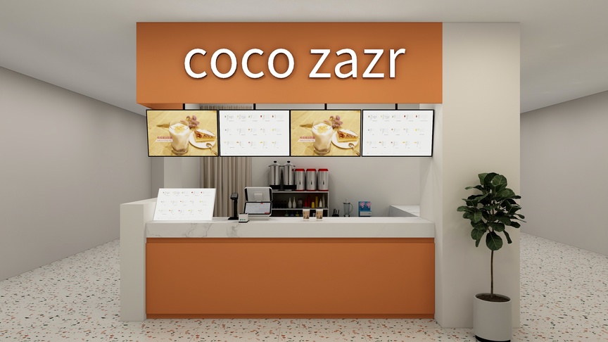 这个场景是一个美食店的内部，店名叫做Coco Zazr。店内的装修风格以橙色和白色为主，给人一种清新明亮的感觉。店内的中央放着一个操作台，上面摆放着各种设备，包括三个白色的盒子和一些银色的管子，看起来像是一个咖啡店。操作台的上方是四张黄色的海报，上面画着各种食物的图片，非常诱人。在操作台的右侧，有一个白色的置物架，上面放着各种杯具和瓶子。在操作台的左侧，立着一台白色的显示器，上面显示着各种信息。在操作台的下方，是一个橙色的储物盒。在店的右侧，放着一个绿色的盆栽，为整个空间增添了一些生机。整个空间的右侧是白色的墙壁，左侧是灰色的墙壁，后面是商场的过道。