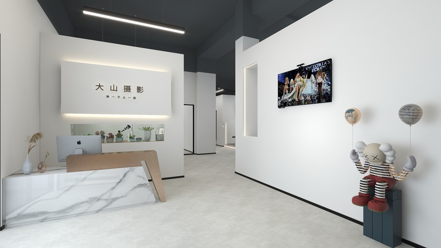 这个白色办公室空间里有几根黑色的龙骨固定在天花板上，带来一种简约而现代的感觉。从入口处看，左手边是公司前台，大理石纹的前台配以一台苹果电脑，背景是白色的墙壁上黑色字体的大山摄影，墙上还挂着一幅艺术画。过道的右侧是公司办公室，墙壁是白色的，墙上还挂着一幅艺术画，画中是两个女人在跳舞。过道的尽头是公司门囗，公司门囗有两盏白色的灯，门口左右两侧各有一个穿草绿色衣服的玩偶，玩偶的中间还夹杂着一个穿红色衣服的玩偶，十分有趣。